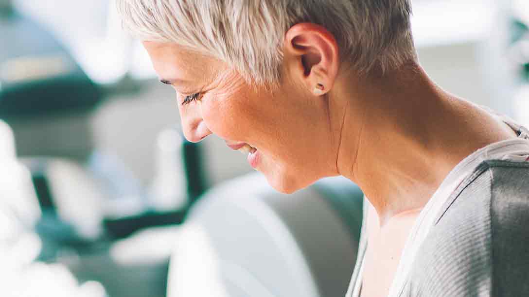 A woman in her 60s smiles in profile