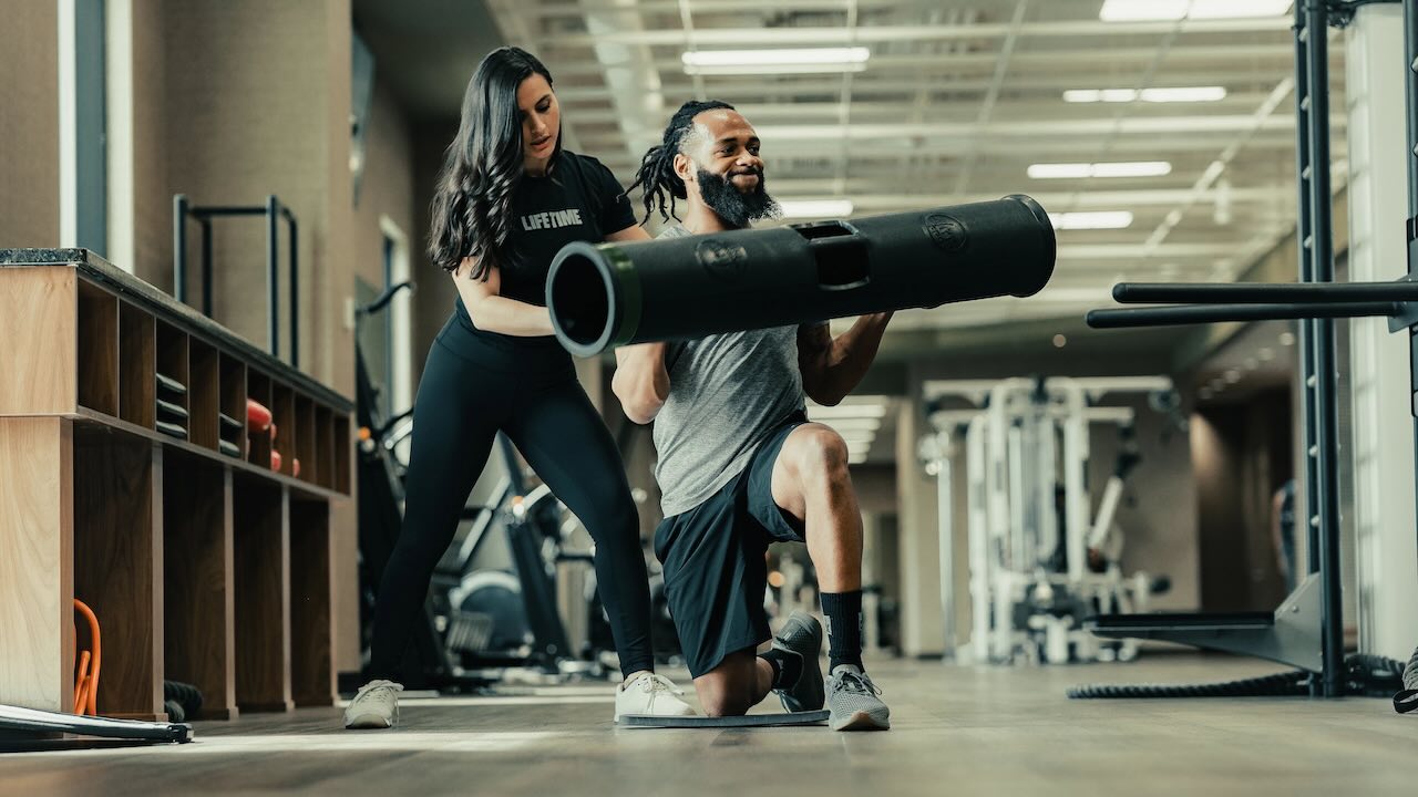 man workingout with a personal trainer